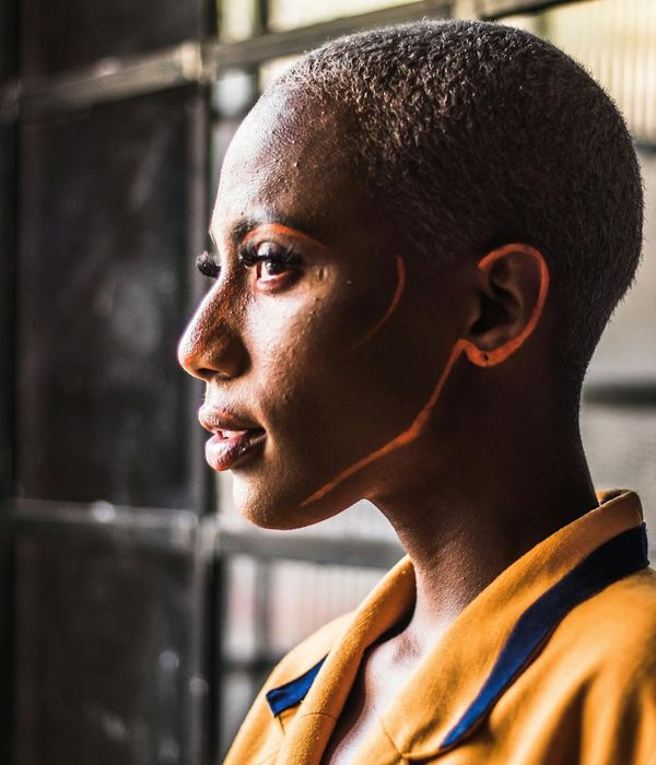 Serene woman looking out a window with a calm expression.
